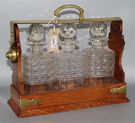 A Victorian oak three-decanter tantalus